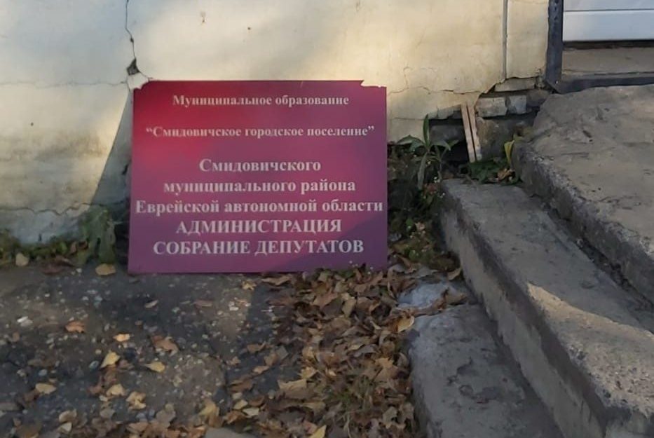 Почти месяц вывеска администрации Смидовичского городского поселения валялась на земле